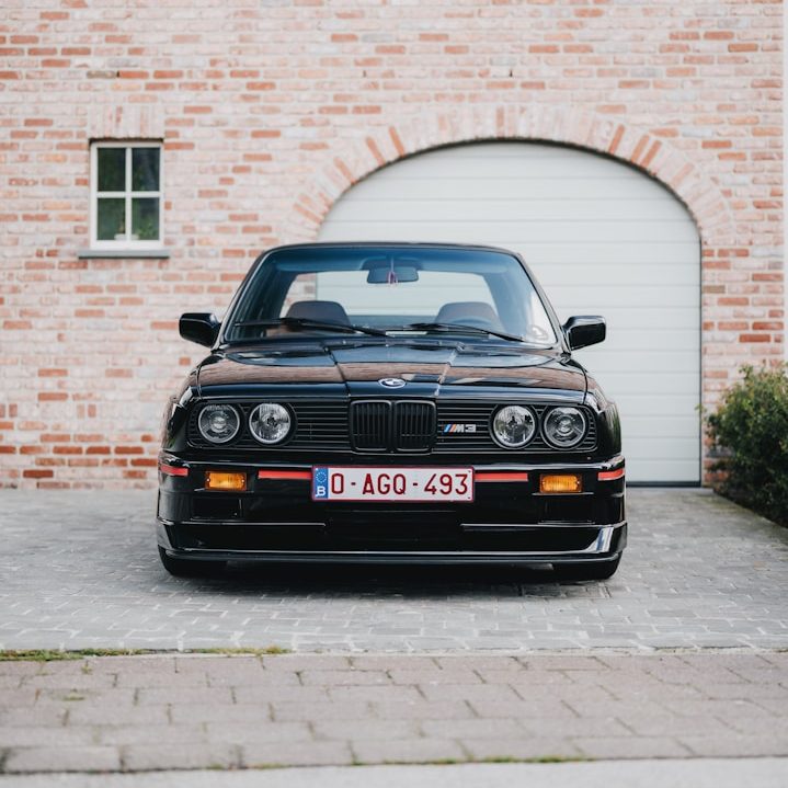 Oldtimer-Zulassung mit H-Kennzeichen BMW E30 vor Garage – Beratung zur Oldtimerzulassung inkl. Rückrüstung durch GRS & SONNE